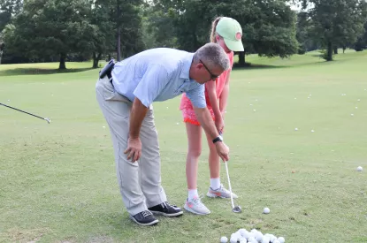 Dan Meyers offers instruction to a young golfer